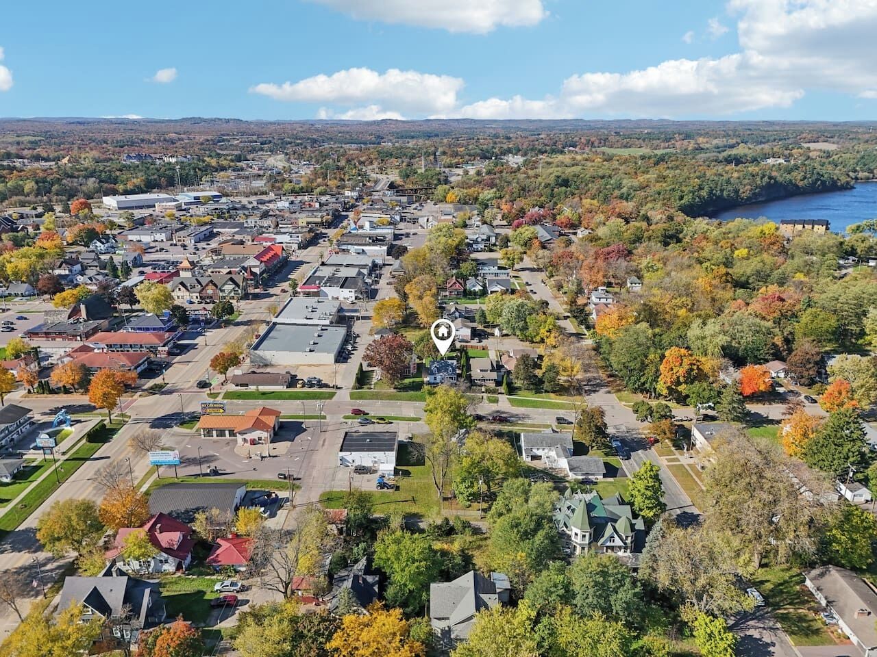 An aerial view of a residential area with houses, streets, and a river in the background.