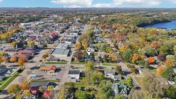 An aerial view of a residential area with houses, streets, and a river in the background.