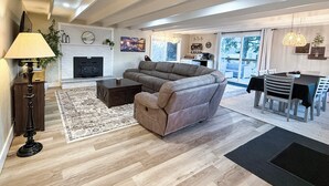 A modern living room with a fireplace, a sofa, a coffee table, and a dining area with a table and chairs. - Hidden Oasis 3BD/2.5BA on secluded 1/2 acre. Sleeps 8, near Reno/Tahoe (Reno)