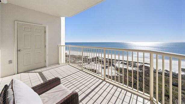 Uma varanda com vista para a praia e o oceano.