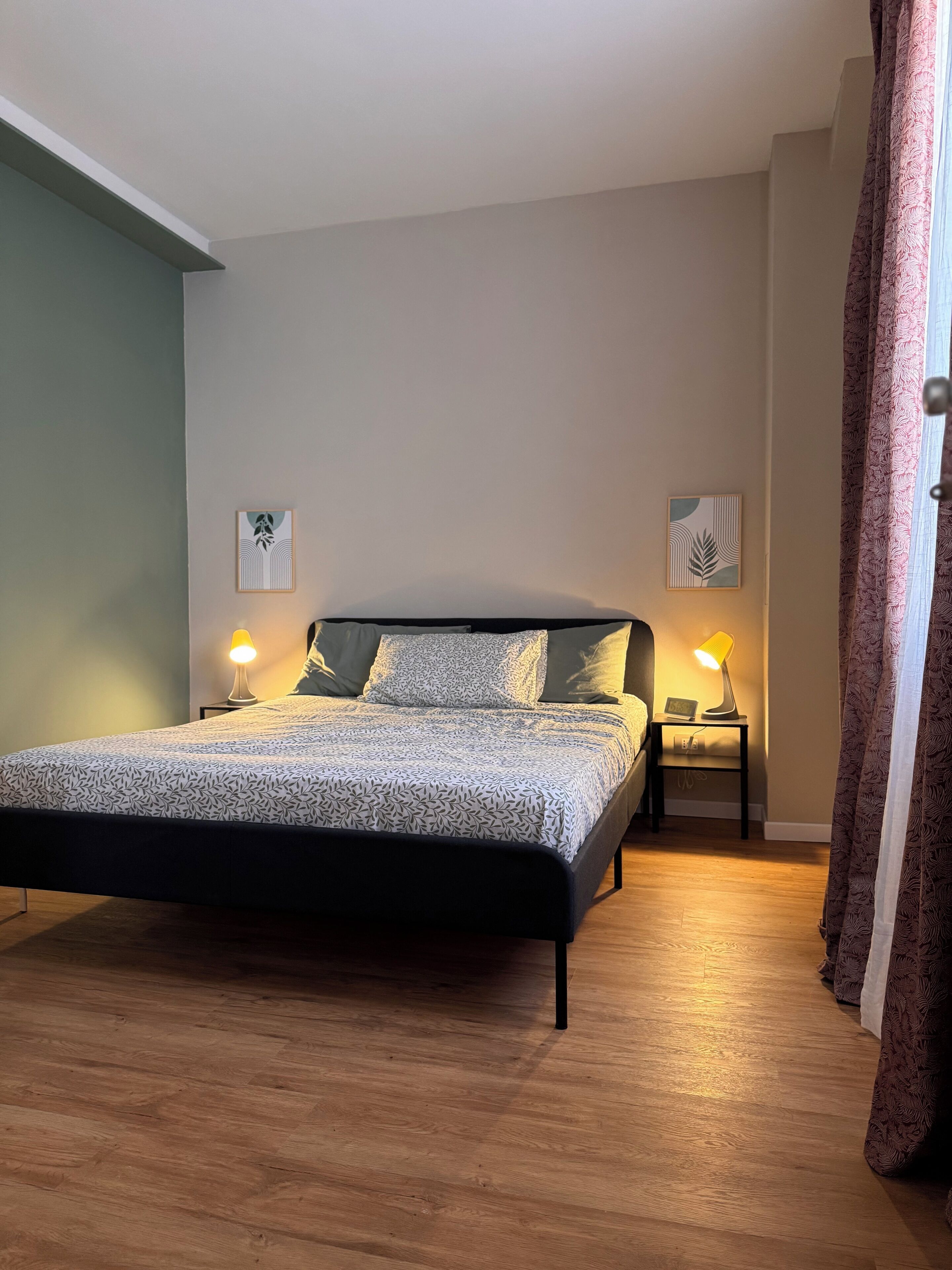 A bedroom with a bed, two bedside lamps, and a nightstand with a lamp.