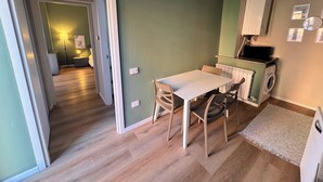 A compact living space with a dining area, a washing machine, and a microwave. - Le dimore di corso Torino  (Novara)