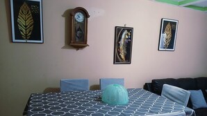 Un comedor con una mesa cubierta por un mantel estampado con motivos geométricos, rodeada de sillas.