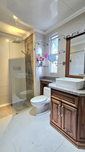 Een douche, handdoeken, zeep, toiletpapier