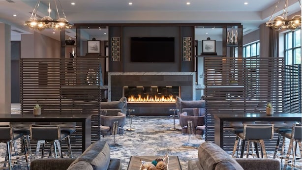 A modern lounge area with a fireplace, sofas, and a dining table. - Refresh and Recharge in a Clean Room Near Cedarwood Playground (Middlesex County)