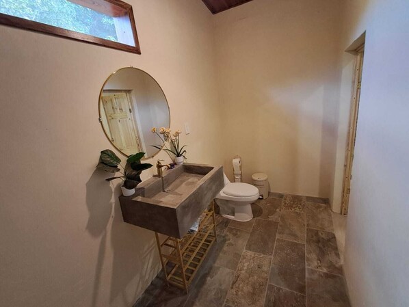A bathroom with a sink, toilet, and a large mirror.