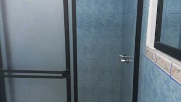 Habitación doble estándar | Baño | Regadera, toallas, jabón, shampoo