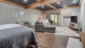 Une chambre spacieuse avec un grand lit, un canapé, une télévision et un balcon offrant une vue agréable.