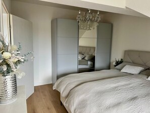 Una camera da letto con un letto, un armadio e un lampadario.