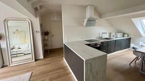 A modern kitchen with a central island, dark cabinets, and a window above the sink. - Living in Ohligs, attic apartment (Solingen)