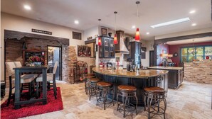 A spacious kitchen with a central island, bar stools, and a red carpet.