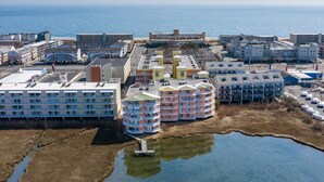 A coastal hotel with multiple buildings, including a large hotel with a flat roof and several smaller structures with colorful facades. - Two Bedroom Updated Condo with Great Amenities (Ocean City)