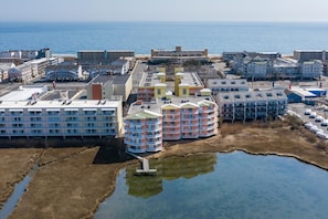 Ein Küstenhotel mit mehreren Gebäuden, darunter ein großes Hotel mit flachem Dach und einige kleinere Bauten mit farbenfrohen Fassaden.