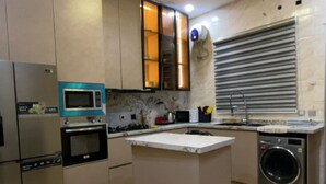 A modern kitchen with stainless steel appliances, a central island, and a built-in oven. - Oral Estate Lekki, Chevron, Executive 4bed ensuite duplex. (Lagos)