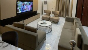 A modern living room with a flat-screen TV, sofas, a coffee table, and a dining area. - Oral Estate Lekki, Chevron, Executive 4bed ensuite duplex. (Lagos)