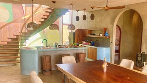 Een moderne keuken met een centraal eiland, houten stoelen en een eettafel.