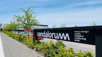 A sign for 'vandalorum' with a list of services including design, studio, and restaurant.