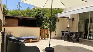 A patio with a sofa, chairs, a table, and a pergola. - Cozy apartment just minutes from the beautiful Mondello beach. (Palermo)