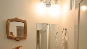 A compact bathroom with a toilet, sink, and mirror. - Beautiful Apartment in los Cocos Santa Marta 1 (Santa Marta)