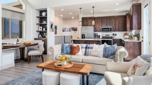 A modern living room with a sofa, coffee table, and dining area. - Perfect Basecamp for Outdoor Fun (Driggs)