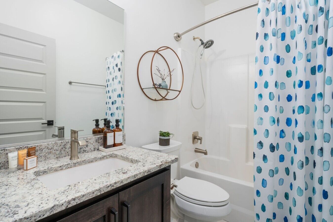 Une salle de bain avec un comptoir en marbre, des toilettes, une baignoire et une douche.