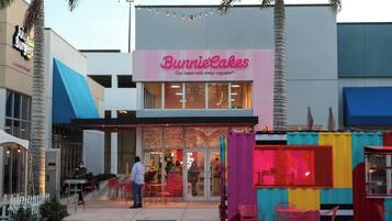 A storefront with a sign reading "Bunnie Cakes" and a colorful outdoor seating area.