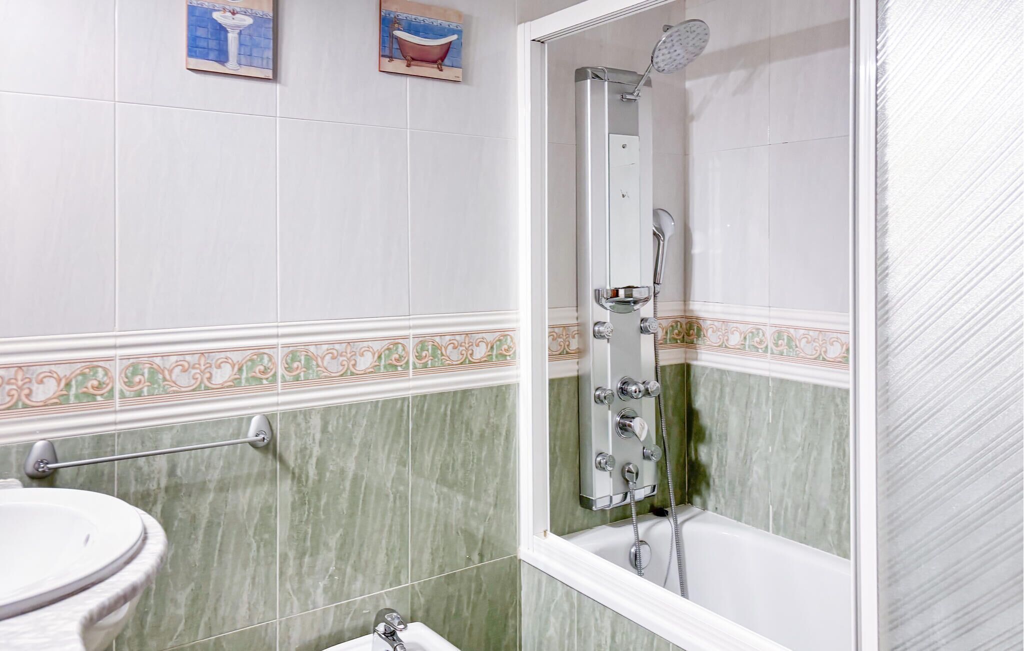 A bathroom with a shower, a sink, and a toilet.