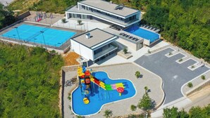 Un edificio moderno con piscina y zona de juegos infantiles.