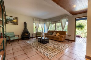 A living room with a fireplace, a sofa, a coffee table, and a rug. - Casa ampla com piscina e churrasqueira  (Carapicuíba)