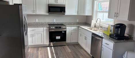 Een microgolfoven, een oven, een kookplaat, een vaatwasser