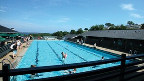 A swimming pool with multiple lanes, a spectator area, and a covered seating area. - Lovely home in Aabenraa with house sea view (Aabenraa)