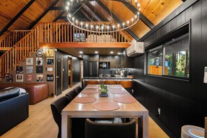 Een moderne keuken met een eethoek, houten plafond en uitzicht op de omgeving.