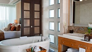 Un baño moderno con una bañera independiente, un tocador de madera y un espejo grande.