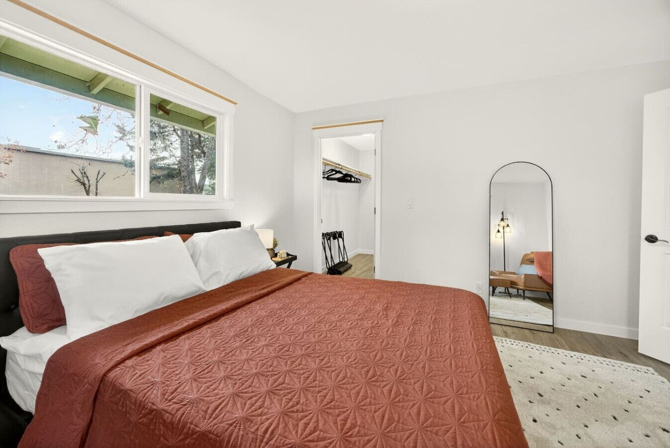 Una camera da letto con un letto grande, uno specchio e vista sull'esterno.