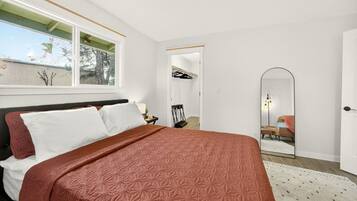 Una camera da letto con un letto grande, uno specchio e vista sull'esterno.