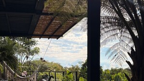 Un'area esterna tranquilla con una piscina in pietra, un'amaca e un'area pranzo sotto una pergola.