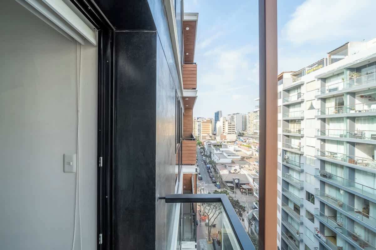 A high-rise building with a balcony overlooking a cityscape.