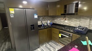 Eine moderne Küche mit Edelstahlgeräten, einer Granit Arbeitsplatte und einem gemusterten Boden.