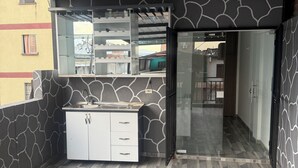 Eine moderne Küche mit integrierter Kücheninsel, einer Glastür zu einem Balkon und einem gemusterten Boden.