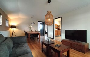 A modern living room with a sofa, dining table, and TV. - Beautiful home in Volkel with WiFi (Volkel)