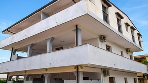 Un edificio a più piani con tetto piatto e un balcone al secondo piano.