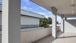 A covered outdoor area with a tiled floor, white walls, and a metal railing. - Amazing apartment in Palmi with swimming pool (Palmi)