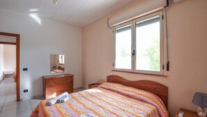 A bedroom with a bed, a dresser, a mirror, and a window. - Amazing apartment in Palmi with swimming pool (Palmi)