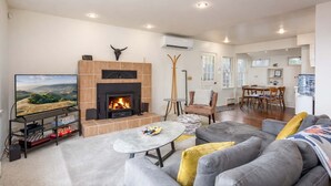 Una sala de estar con chimenea, televisor y comedor.