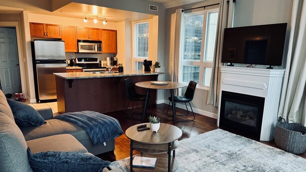 Una sala de estar moderna con un sofá gris, una mesa de centro y una chimenea.