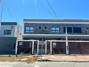 Ein modernes, zweistöckiges Gebäude mit Garage, deren Garagentore die Nummern 03 und 04 tragen.