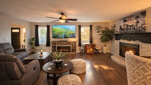 Ein Wohnzimmer mit Kamin, Fernseher und Sitzecke.