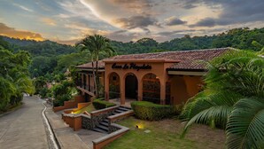 A building named "Casa La Playa" with a tiled roof, arched entrance, and a staircase leading to the entrance. - Casa Plazoleta 4 bdr private pool in Los Suenos (Herradura)