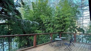 A wooden deck with a view of a lake, surrounded by trees. - Charming Private Suburban Cottage, Serene & Cozy (Mount Vernon)