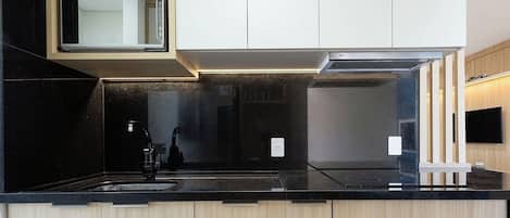 A modern kitchen with a built-in microwave, a stove, and a sink.